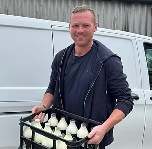 Mark carrying a crate of milk