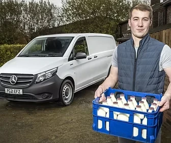 John holding a crate of milk